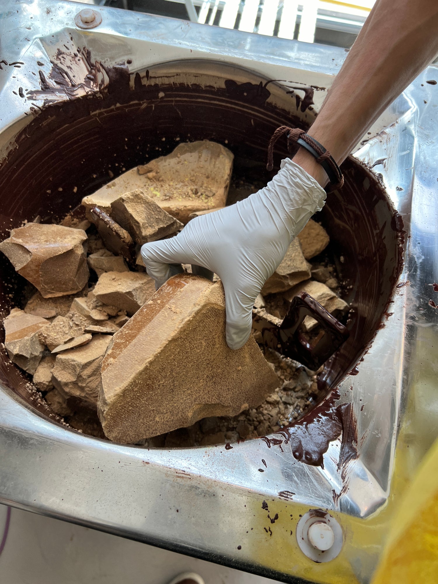 Pouring pure cocoa mass into melted single origin Nicaraguan chocolate