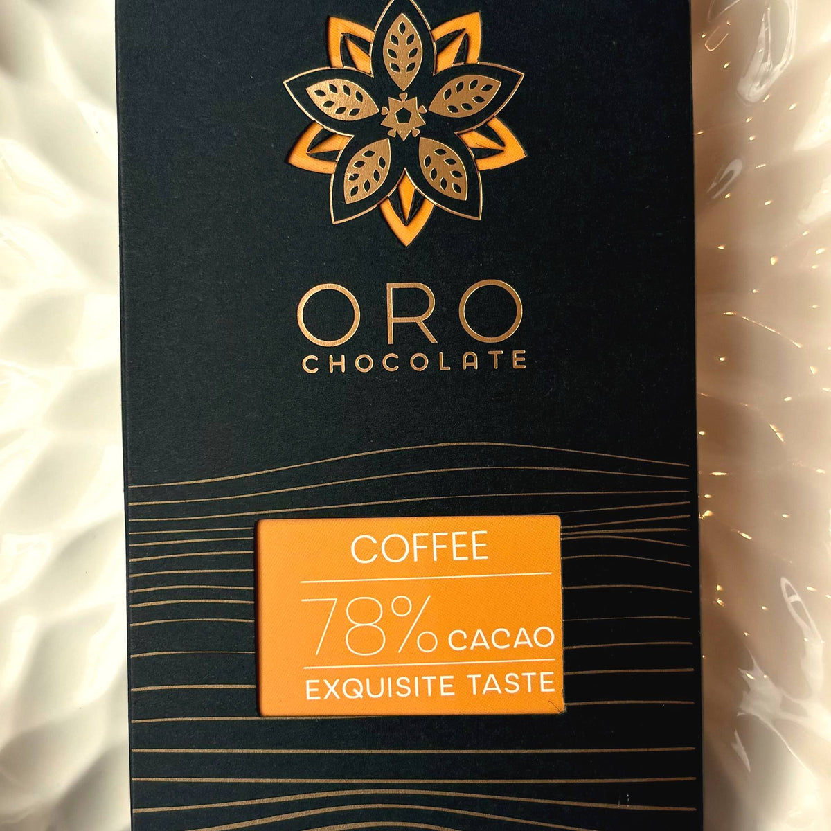 Close-up of the Oro Coffee 78% cacao chocolate bar label and the gold Oro flower mark on the black pack