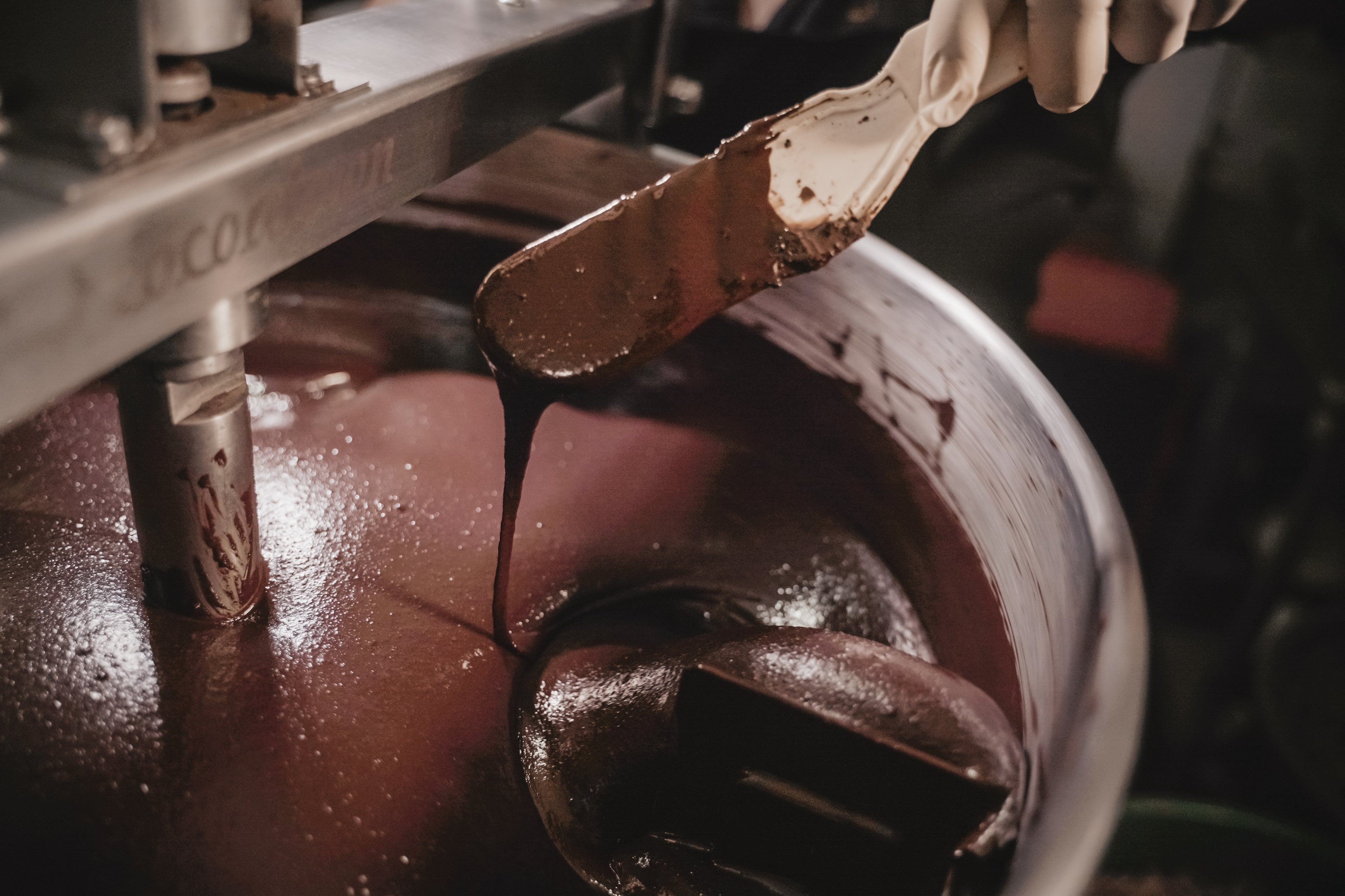 Stone-ground Nicaraguan chocolate ribboning off the spatula in the melangeur at Oro&