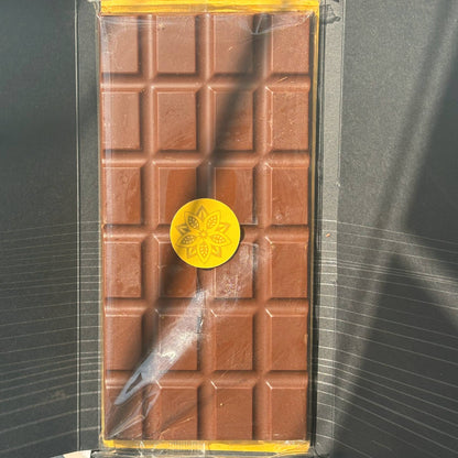 An Oro bar unwrapped from its black sleeve, the chocolate with a gold Oro seal, seen from above