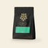 A 12oz bag of Oro single-origin Nicaraguan coffee, natural process, on a cream background