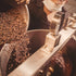 A chocolate maker pouring cacao nibs into the stone melangeur at Oro&
