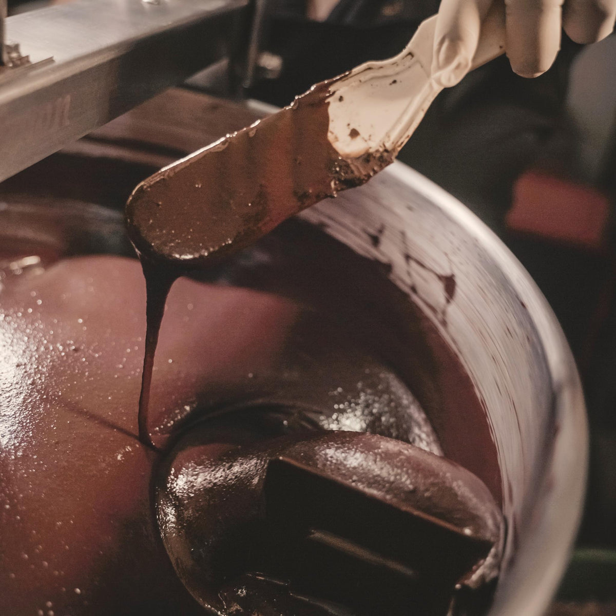 Stone-ground Nicaraguan chocolate ribboning off the spatula in the melangeur at Oro&
