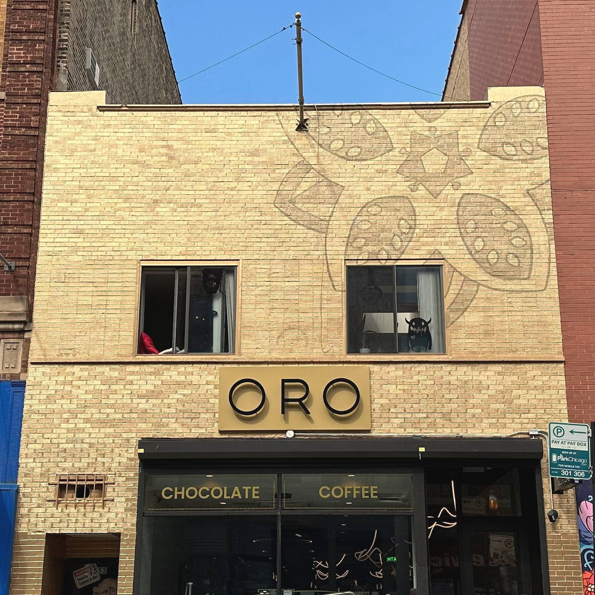 The Oro building at 1553 N Milwaukee Ave, Wicker Park: a gold brick front with large cacao pods drawn across the upper wall and a gold ORO sign