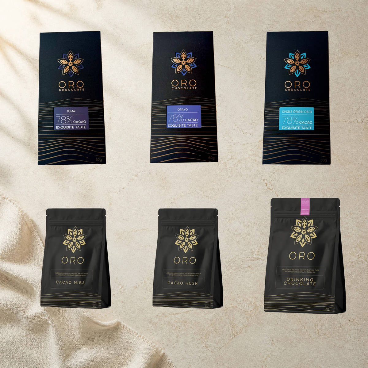 Editorial arrangement of Oro Tuma, Opayo and Single Origin Dark 78% bars, cacao nibs, cacao husk tea and Ceremonial 100% drinking chocolate on cream stone.
