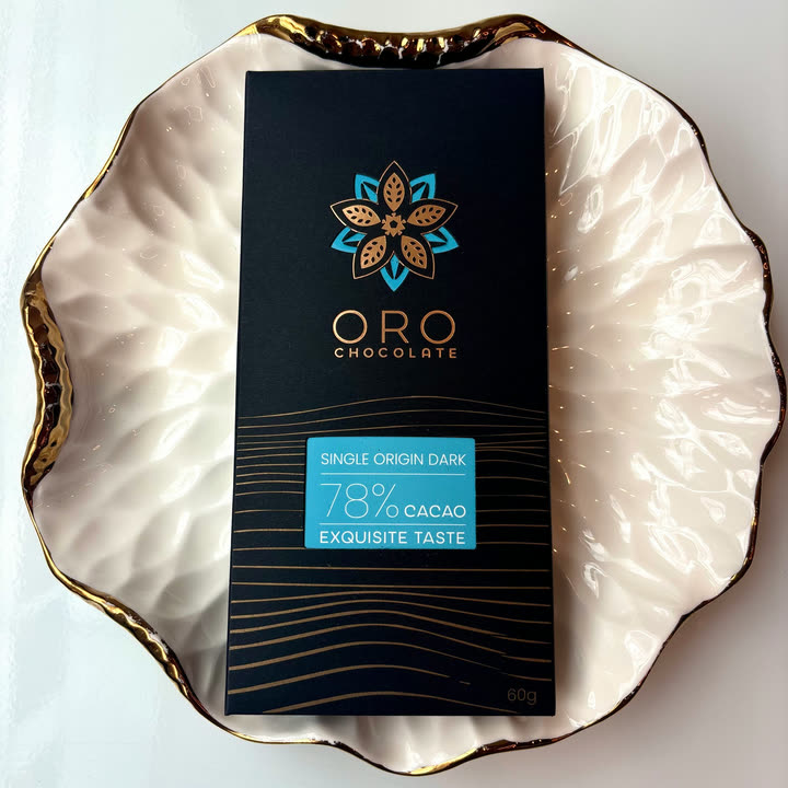 An Oro Single Origin Dark 78% bar on a white plate with a gold rim