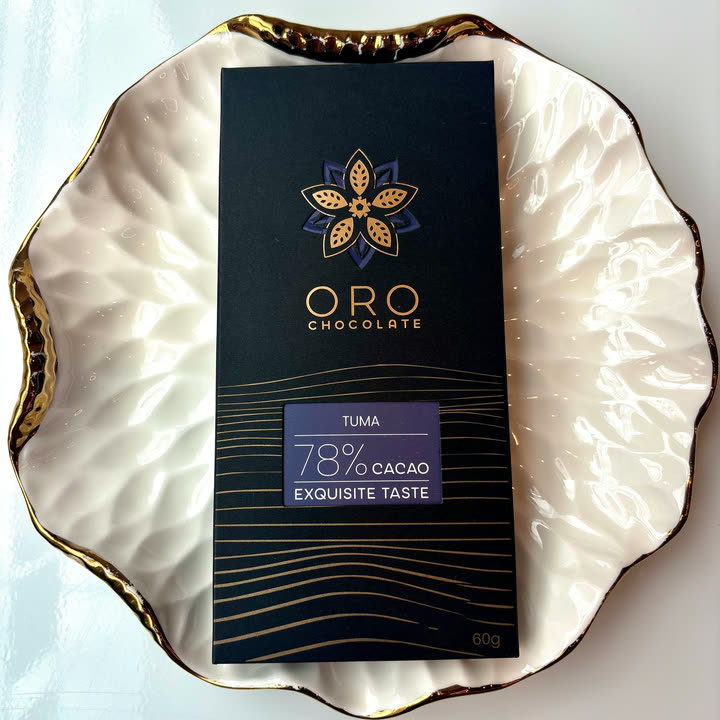 An Oro Tuma 78% bar on a white plate with a gold rim