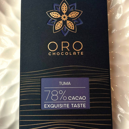Close-up of the Oro Tuma 78% cacao chocolate bar label and the gold Oro flower mark on the black pack